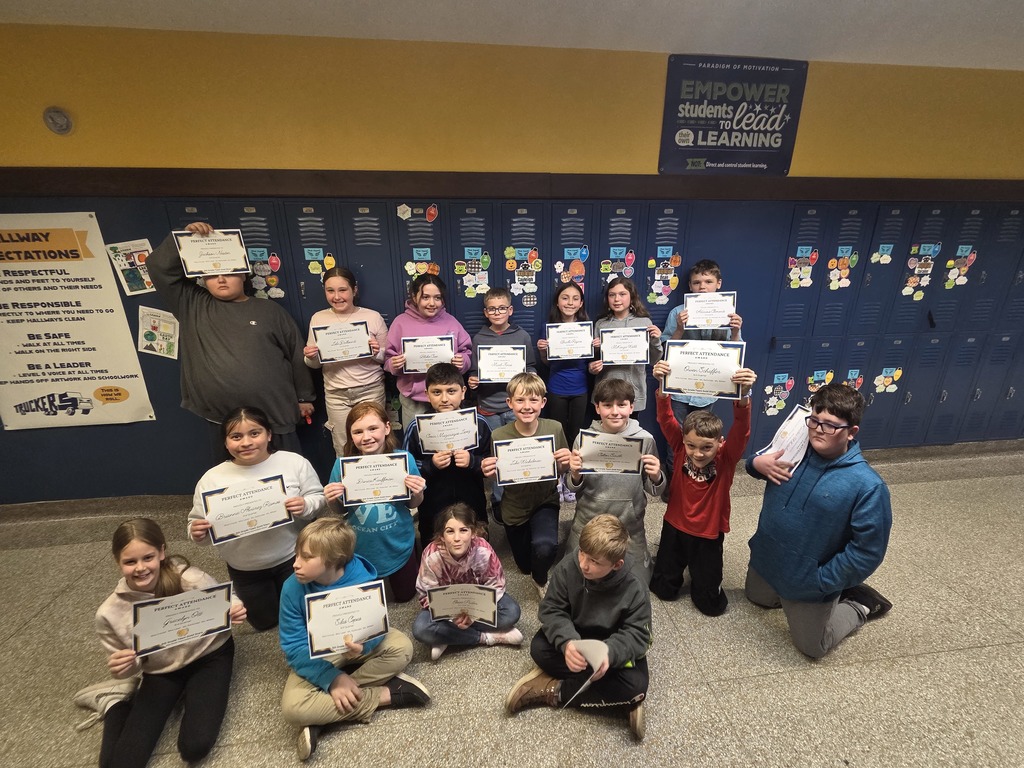 kids on floor holding certificates for perfect attendance