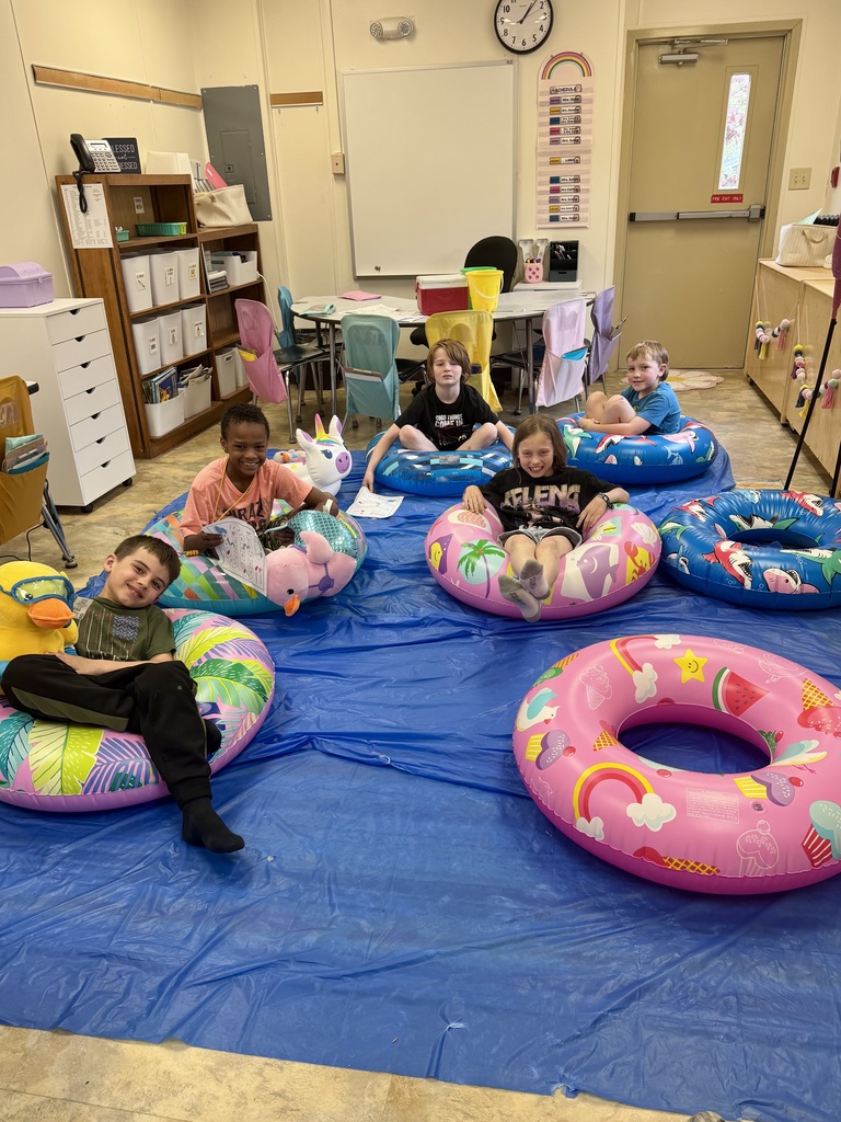 kids on pool floats reading