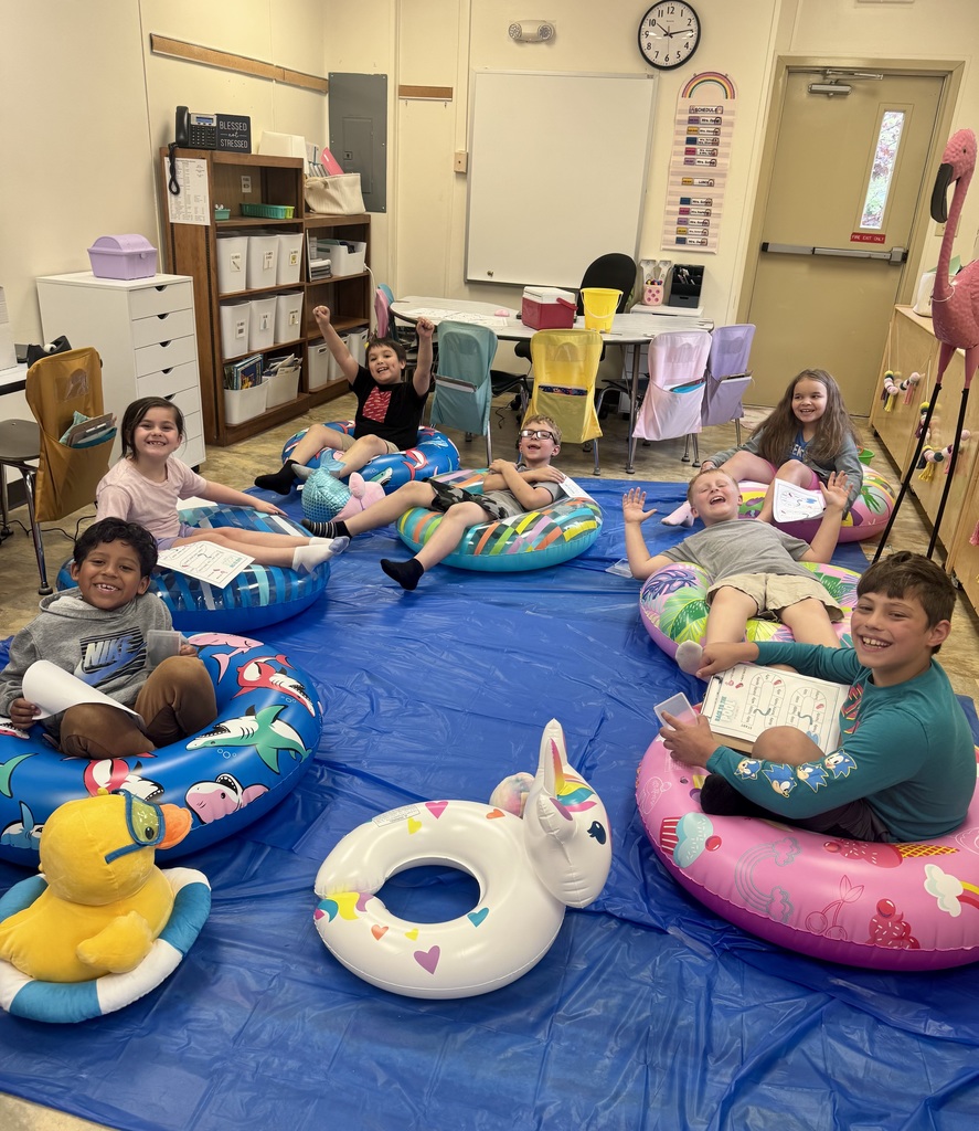 kids on pool floats reading