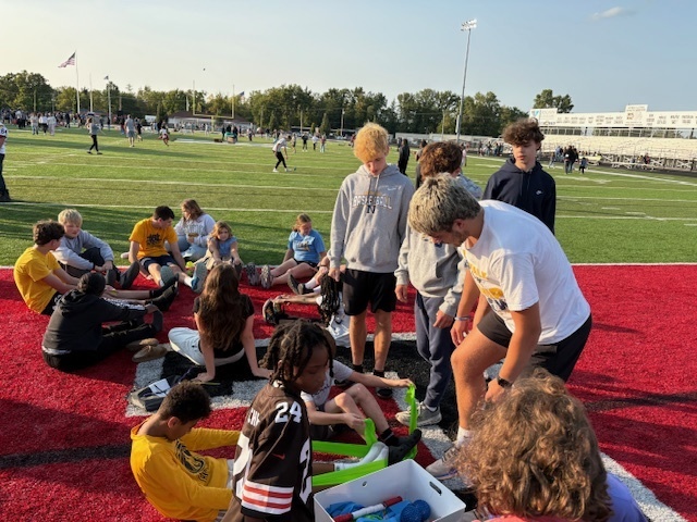 High School Cross Country and Track team doing stretches with the kids during Reading Under the Lights