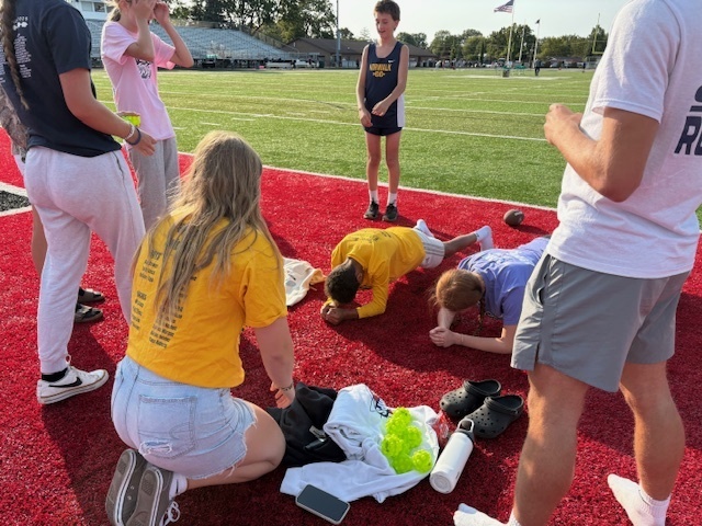 High School Cross Country and Track team doing stretches with the kids during Reading Under the Lights