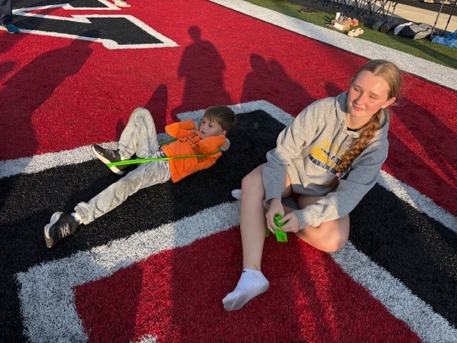 High School Cross Country and Track team doing stretches with the kids during Reading Under the Lights