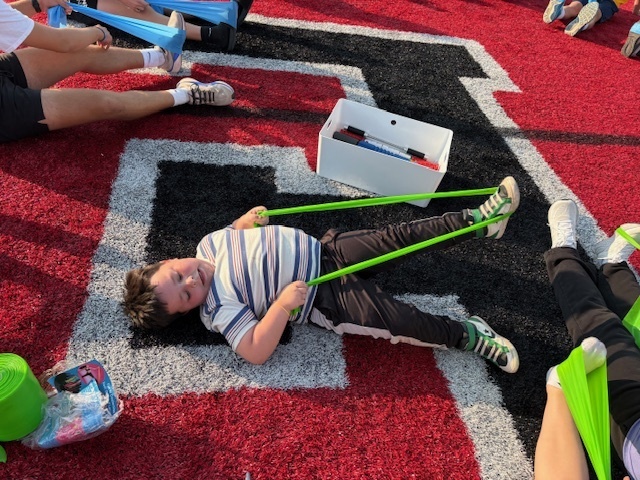 High School Cross Country and Track team doing stretches with the kids during Reading Under the Lights