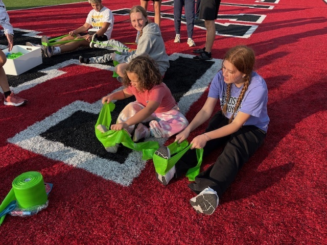 High School Cross Country and Track team doing stretches with the kids during Reading Under the Lights