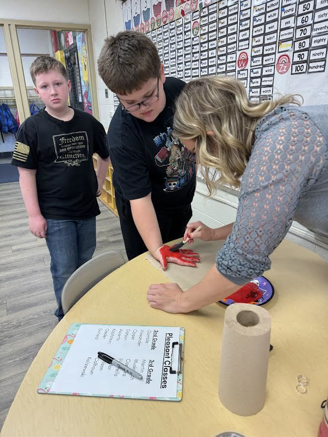 2nd & 3rd Graders at Pleasant Elementary collaborated to make a handprint flag in honor of our Veteran family members and friends. It is hanging on display in the gym/cafeteria.