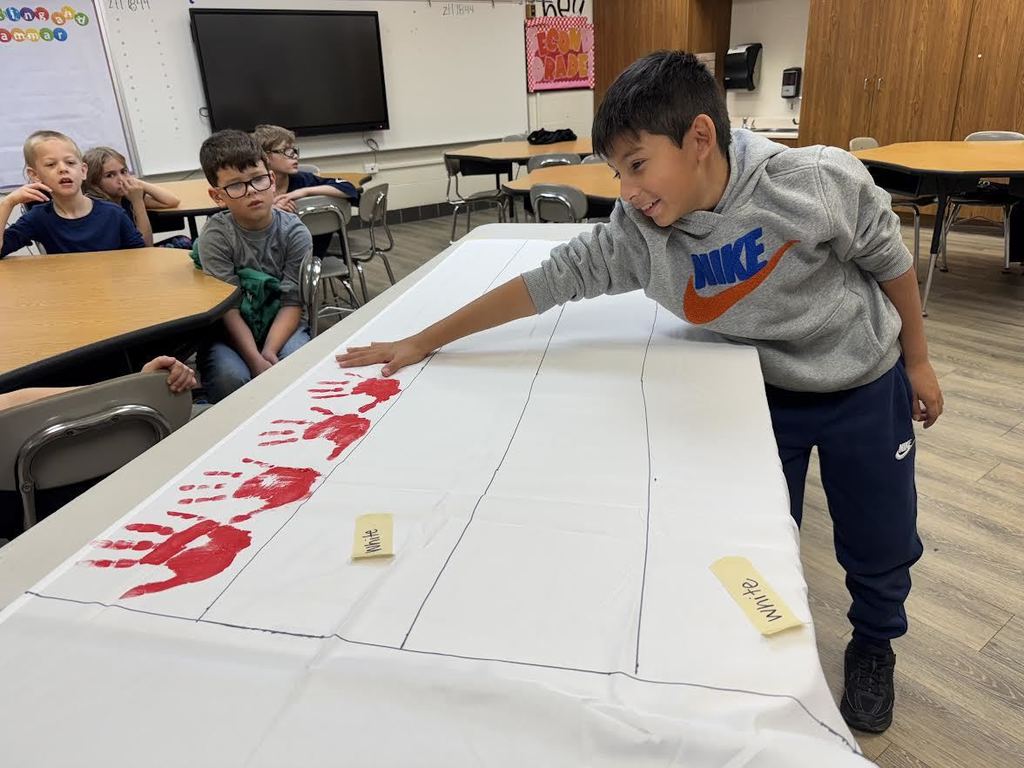 2nd & 3rd Graders at Pleasant Elementary collaborated to make a handprint flag in honor of our Veteran family members and friends. It is hanging on display in the gym/cafeteria.