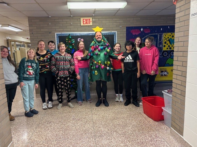 Middle School students who contributed ten or more cans to the building's canned food drive got the opportunity to decorate a "Christmas Tree" (Mr. Bement) on Friday. The school exceeded its original goal of 300 cans by bringing in over 1100 canned and nonperishable food items during the week-long drive, all of which benefited local families. Mr. Bement agreed to don the costume as part of the incentive for having such a successful collection.