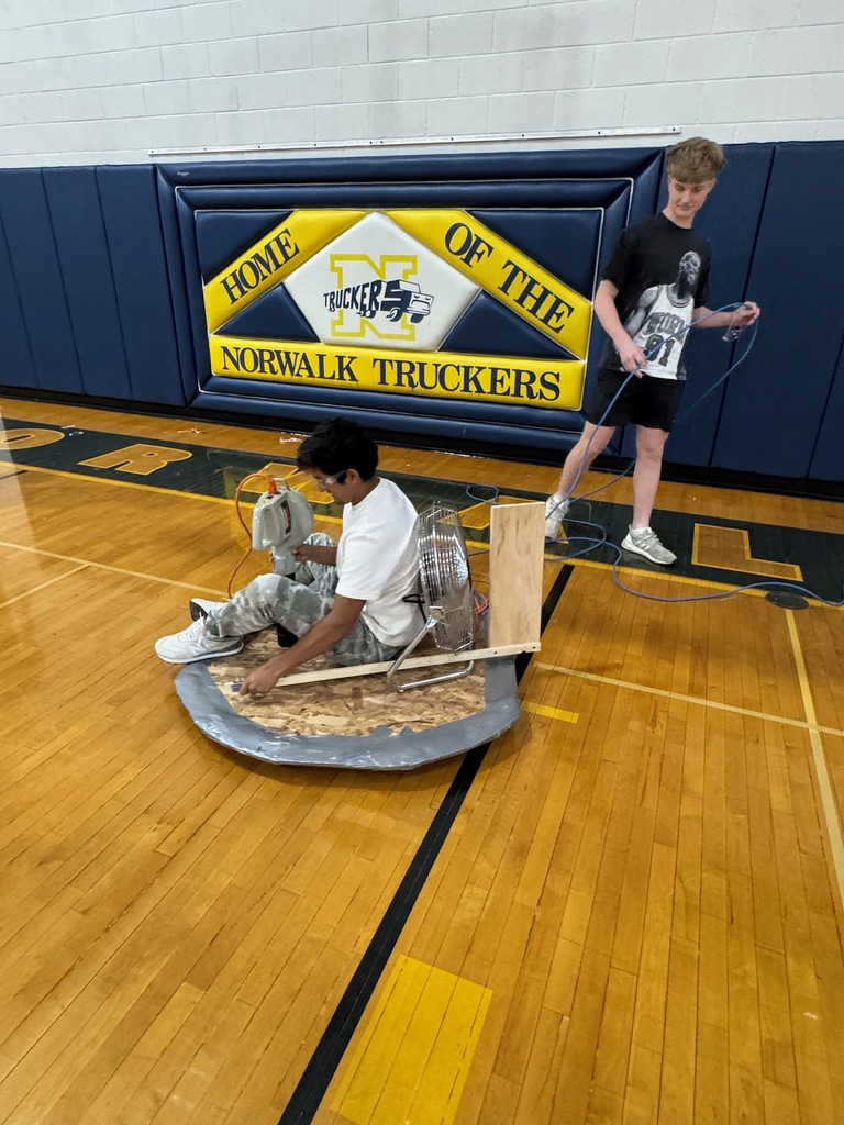 Victor Negrete test rides his hovercraft he built in Industrial Education 2 while his partner LJ Odell assists him with the power cord. 