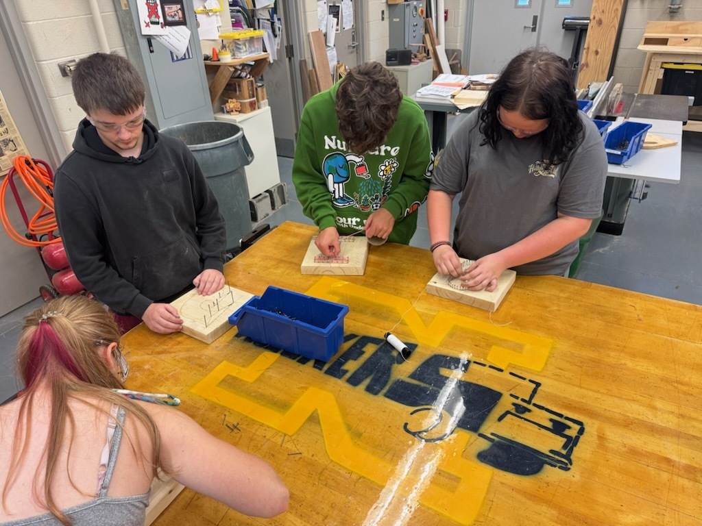 Students in Industrial Education 1 working on their string art projects.