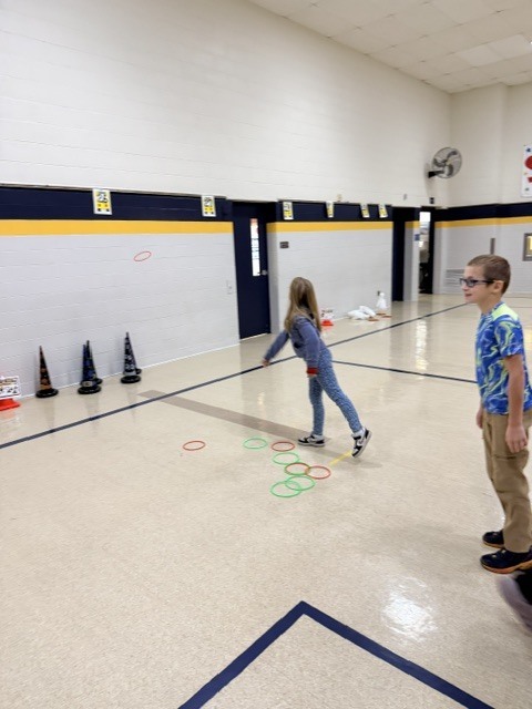 2nd and 3rd grade PE students are having fun reviewing underhand throwing, rolling, and catching with Halloween stations. Mrs. Loomis joined in on the fun and was showing the kids her skills!