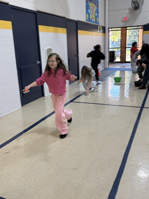 2nd and 3rd grade PE students are having fun reviewing underhand throwing, rolling, and catching with Halloween stations. Mrs. Loomis joined in on the fun and was showing the kids her skills!