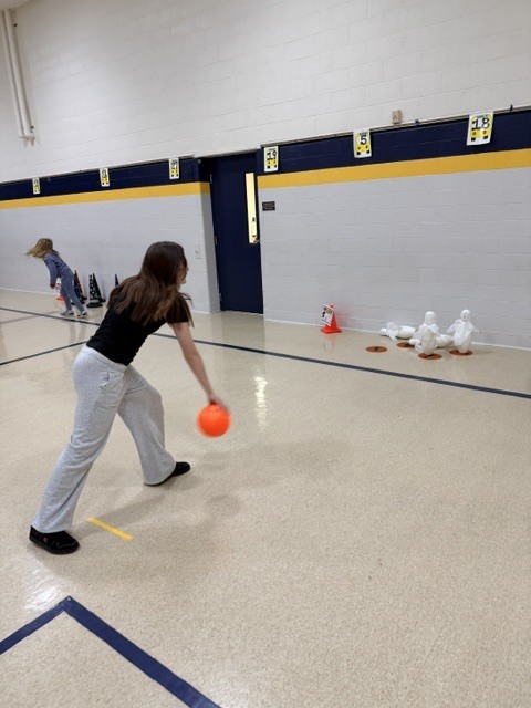 2nd and 3rd grade PE students are having fun reviewing underhand throwing, rolling, and catching with Halloween stations. Mrs. Loomis joined in on the fun and was showing the kids her skills!