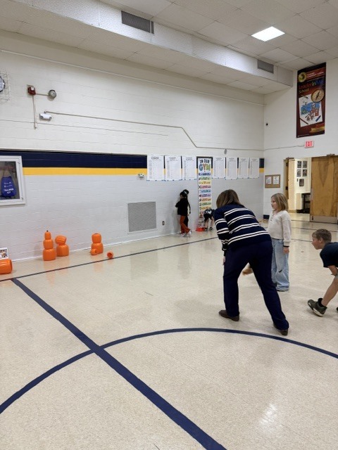 2nd and 3rd grade PE students are having fun reviewing underhand throwing, rolling, and catching with Halloween stations. Mrs. Loomis joined in on the fun and was showing the kids her skills!