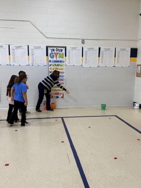 2nd and 3rd grade PE students are having fun reviewing underhand throwing, rolling, and catching with Halloween stations. Mrs. Loomis joined in on the fun and was showing the kids her skills!