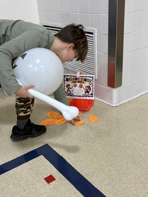 2nd and 3rd grade PE students are having fun reviewing underhand throwing, rolling, and catching with Halloween stations. Mrs. Loomis joined in on the fun and was showing the kids her skills!
