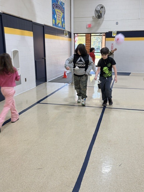 2nd and 3rd grade PE students are having fun reviewing underhand throwing, rolling, and catching with Halloween stations. Mrs. Loomis joined in on the fun and was showing the kids her skills!