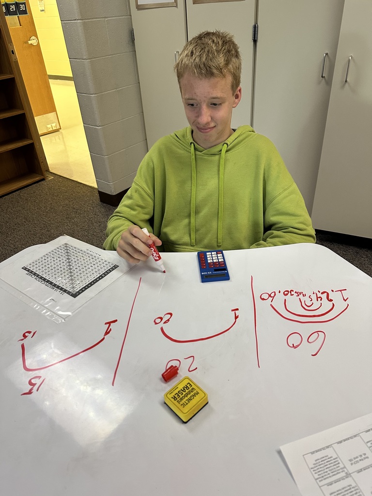 Student doing math on the dry erase table