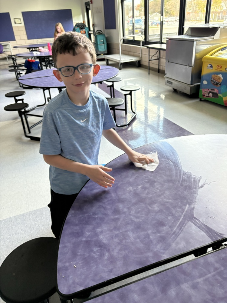 student wiping down table