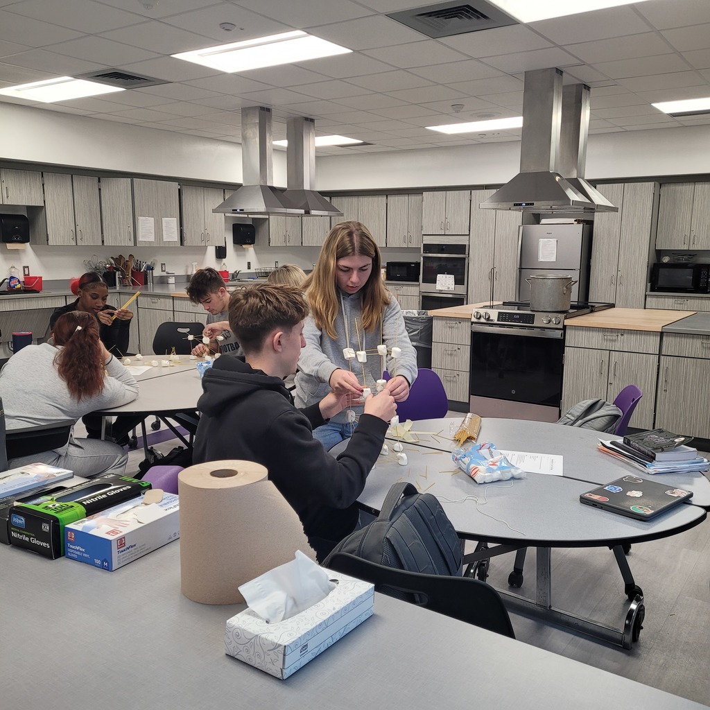 Raegan Doliver and Charlie Smith creating a tower out of Marshmallows for a team building experience.
