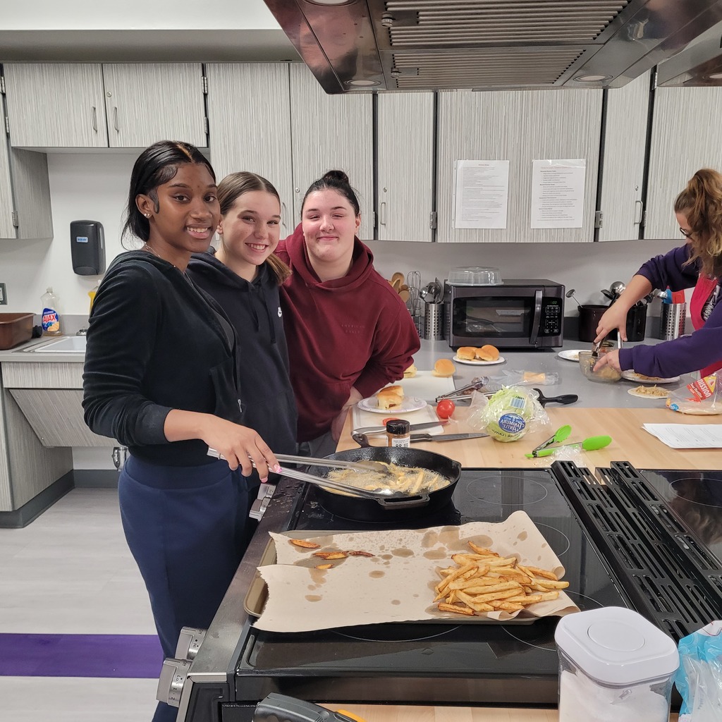 Melanie Morales, Breylyn Eaton, and Makenzie Spade making Hamburgers and Fries with homemade pickles.