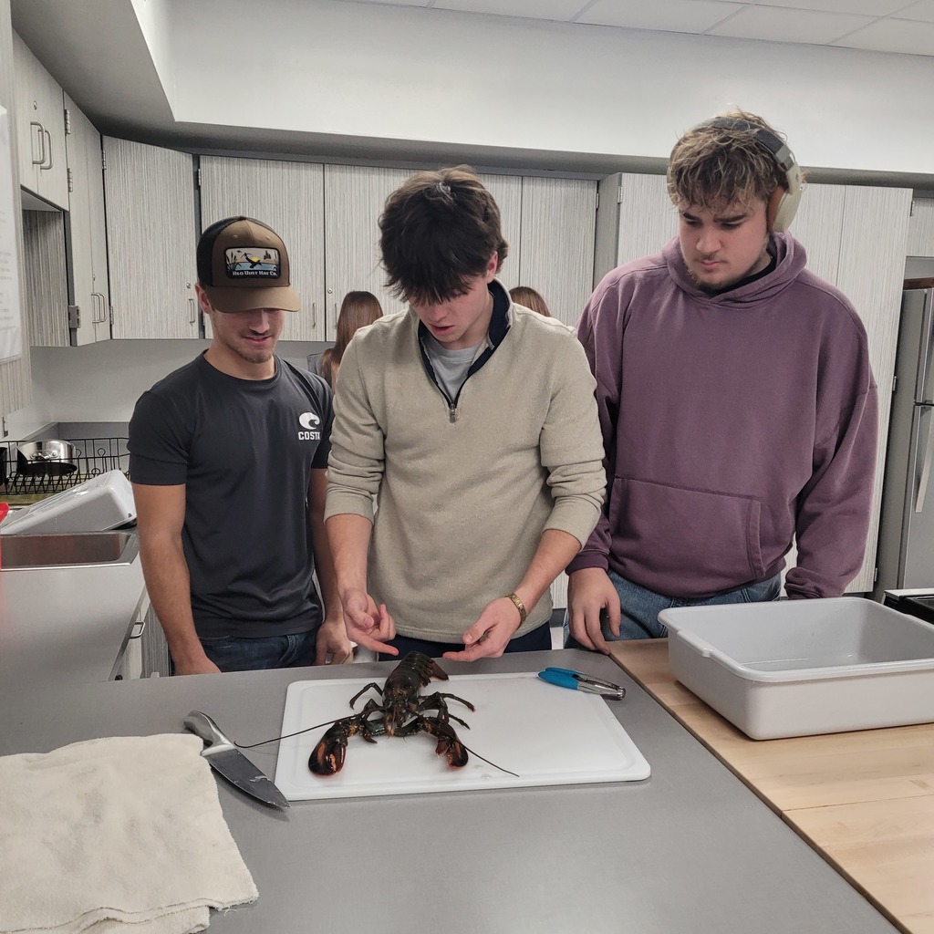 Joshua Lindridge, Zack Parker, and Liam White inspecting a lobster.