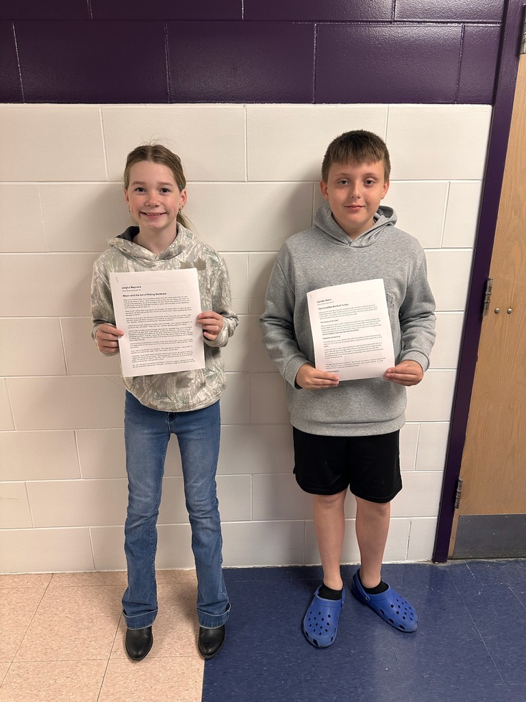 Two students holding writing