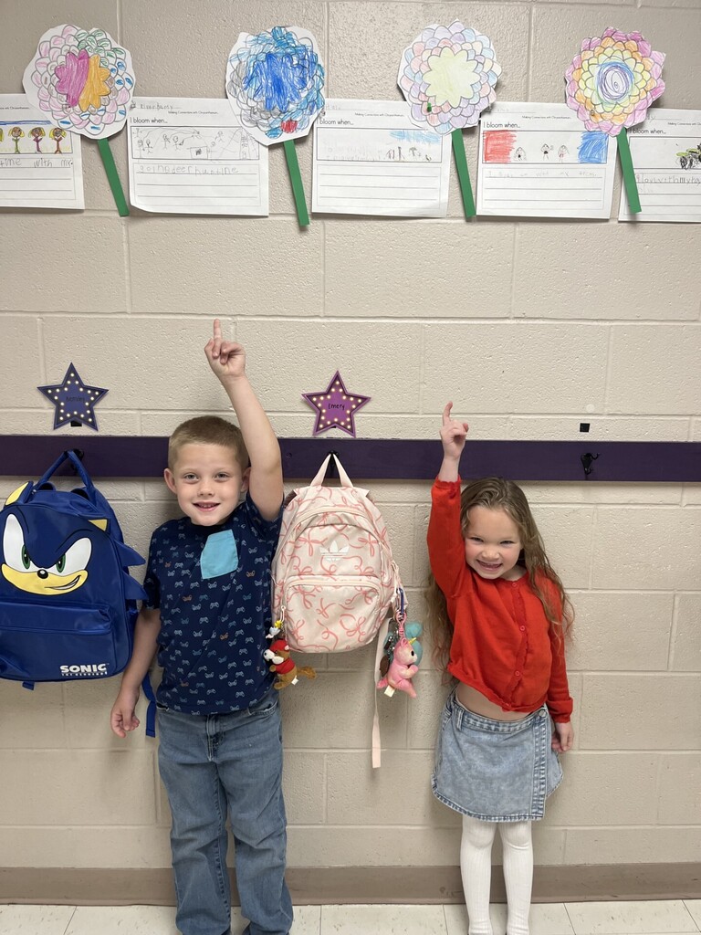 Photo of two students smiling in front of their Chrysanthemum crafts.