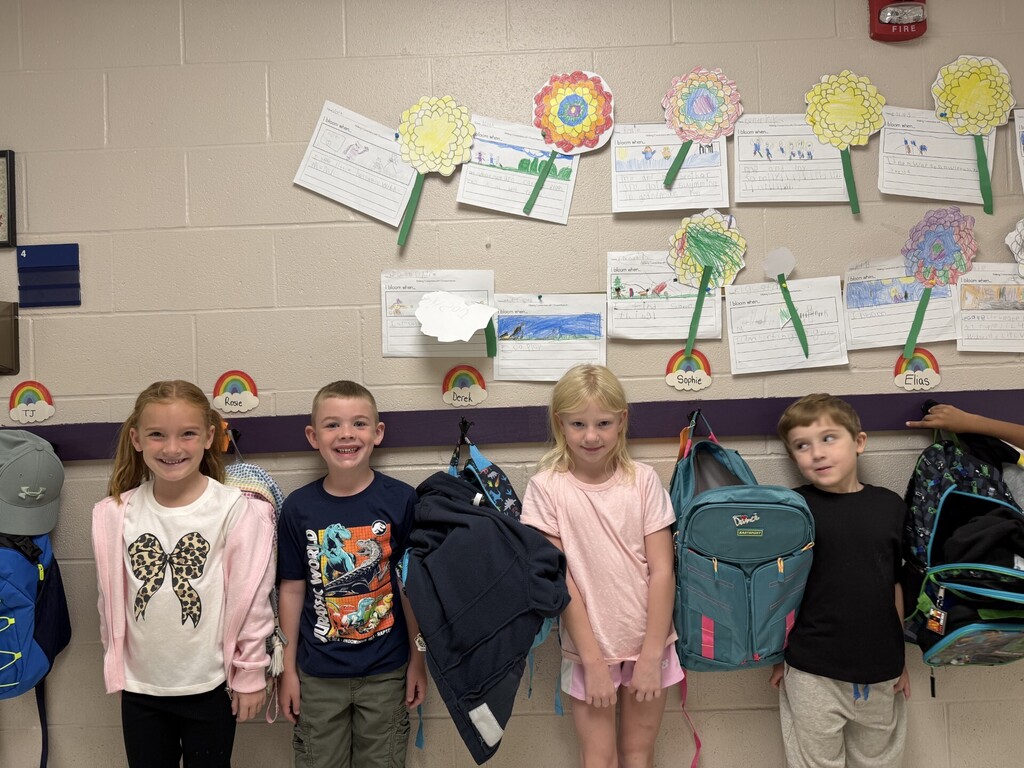 Photo of four students smiling in front of their Chrysanthemum crafts.