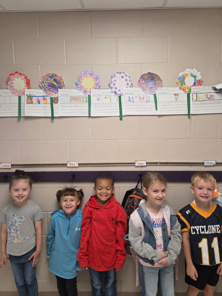Photo of five students smiling in front of their Chrysanthemum crafts.