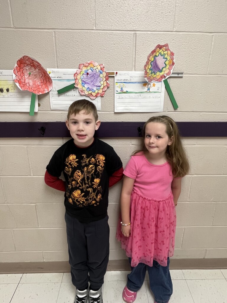 Photo of 2 students smiling in front of their Chrysanthemum crafts.