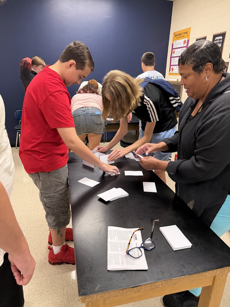Students working together to build a tower with notecards.