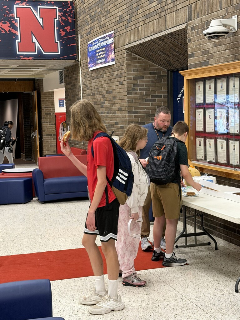 Students in NHS Lobby receiving donut prize