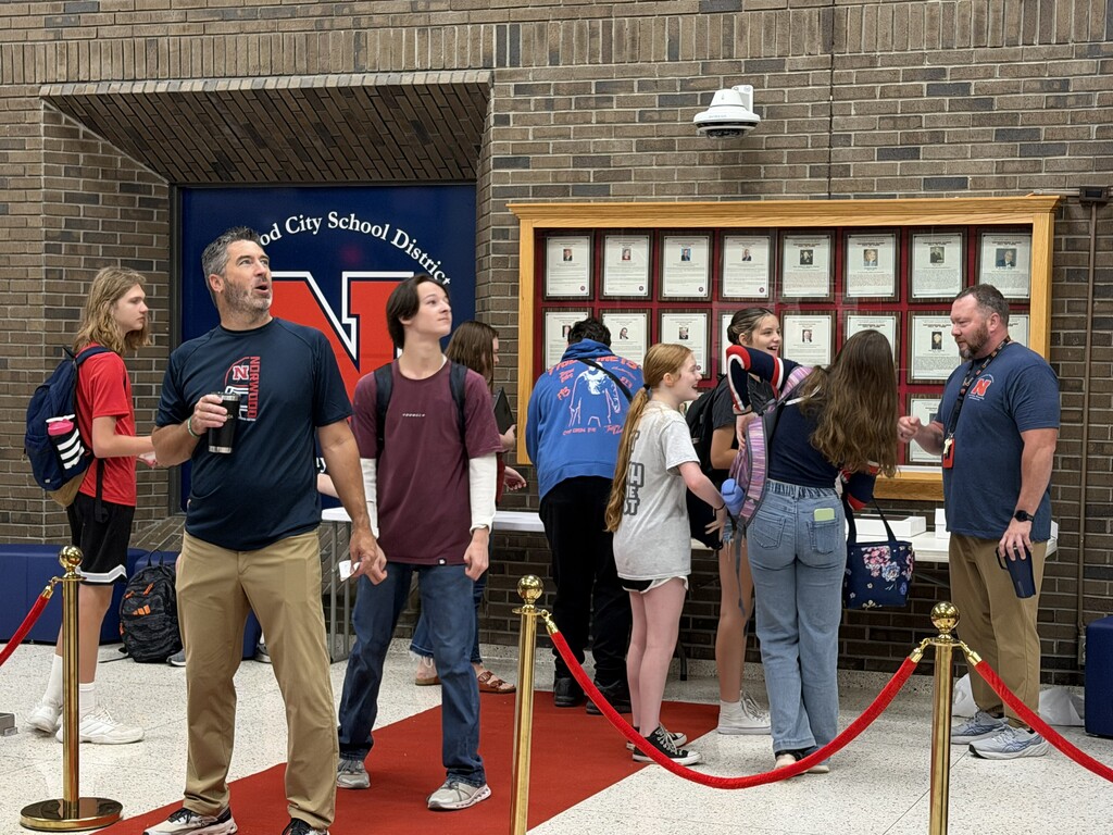 Students in NHS Lobby receiving donut prize