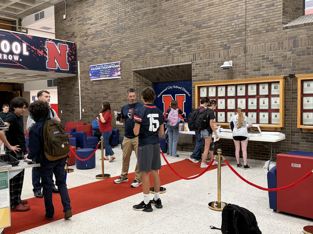 Students in NHS Lobby receiving donut prize