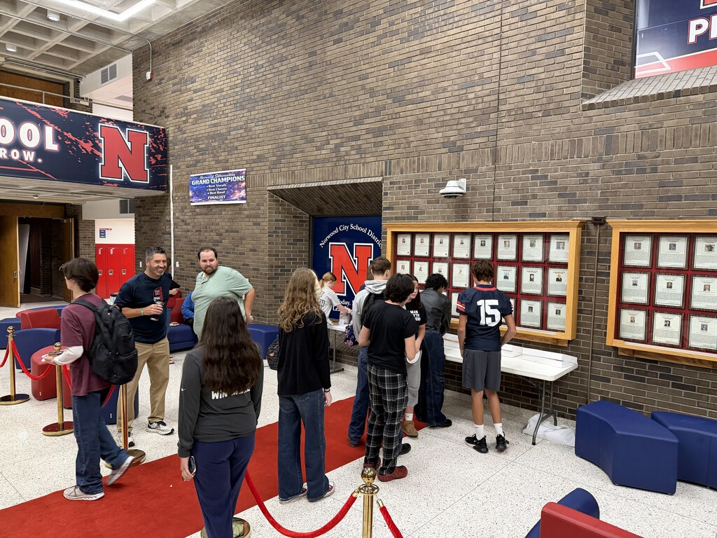 Students in NHS Lobby receiving donut prize
