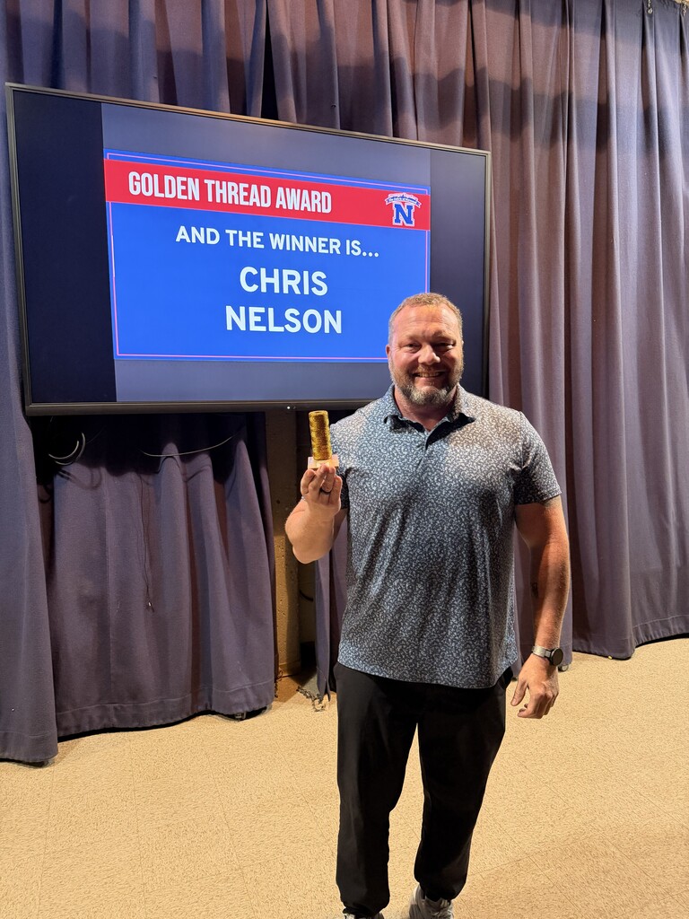 Chris Nelson holding Golden Thread Award