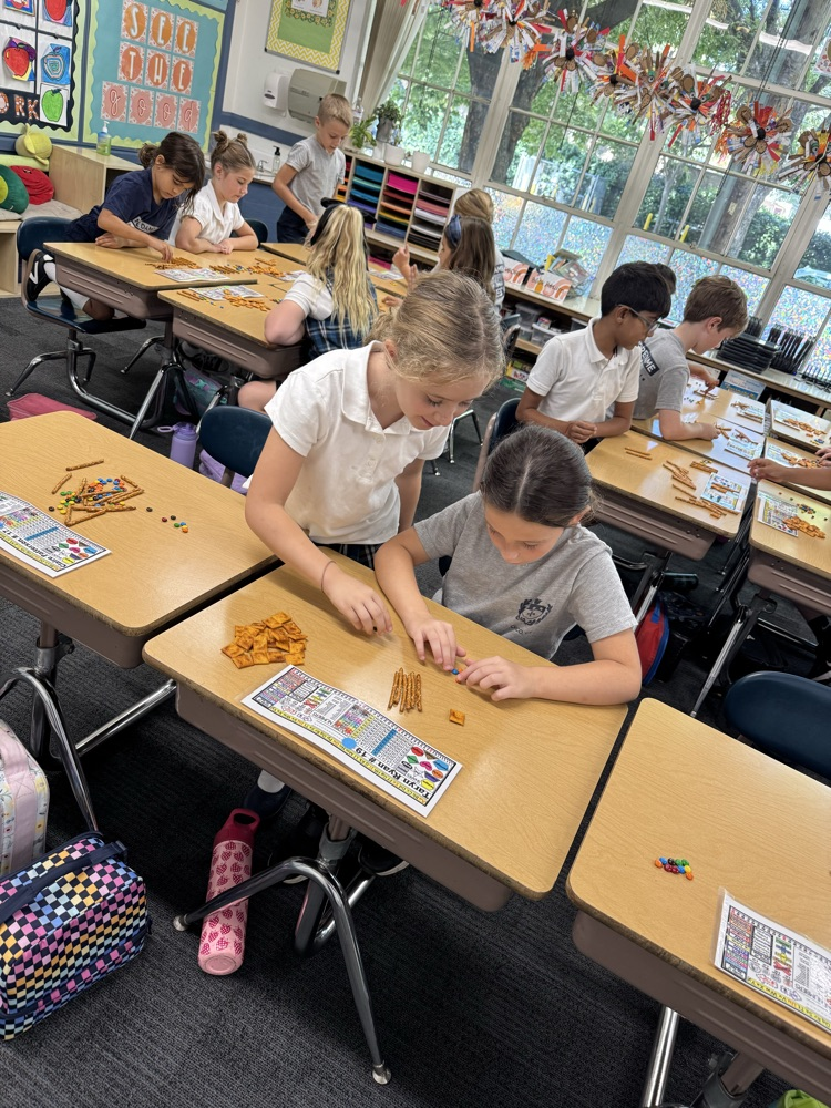 Second grade uses food for Fun Friday to solve double and triple digit addition using 100s, 10s, 1s