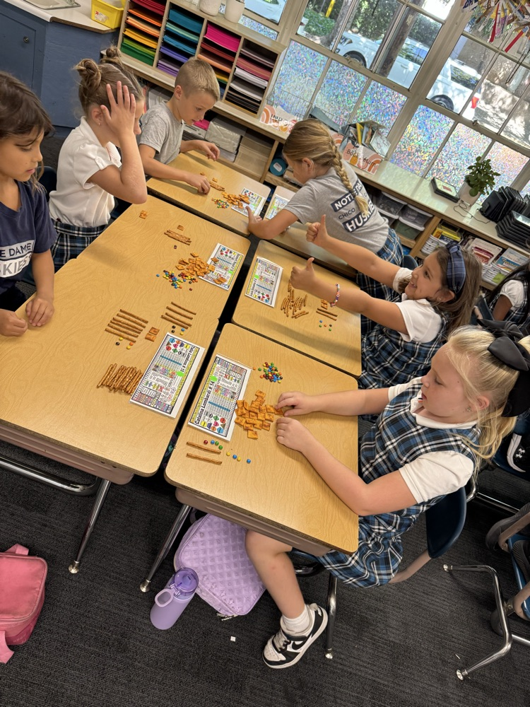 Second grade uses food for Fun Friday to solve double and triple digit addition using 100s, 10s, 1s