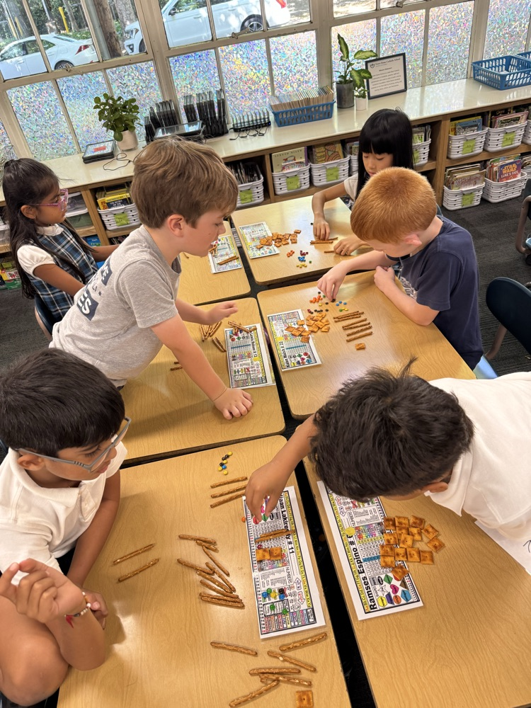 Second grade uses food for Fun Friday to solve double and triple digit addition using 100s, 10s, 1s