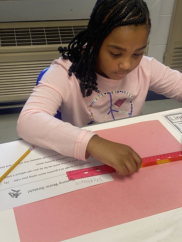 Second grade students measuring gummy worms.