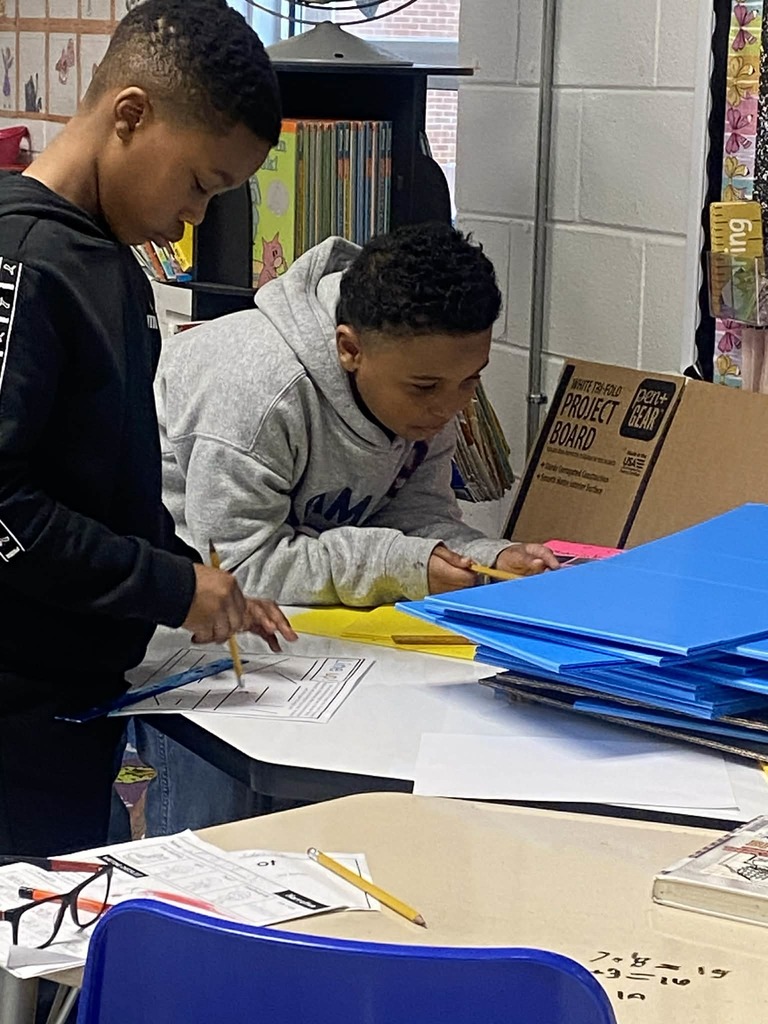 Second grade students measuring gummy worms.