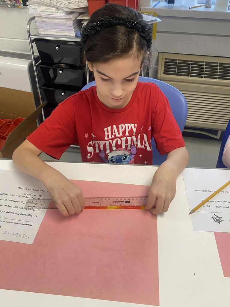 Second grade students measuring gummy worms.