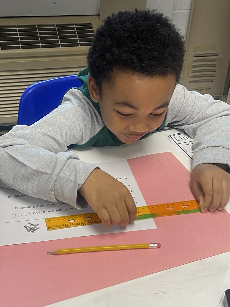 Second grade students measuring gummy worms.