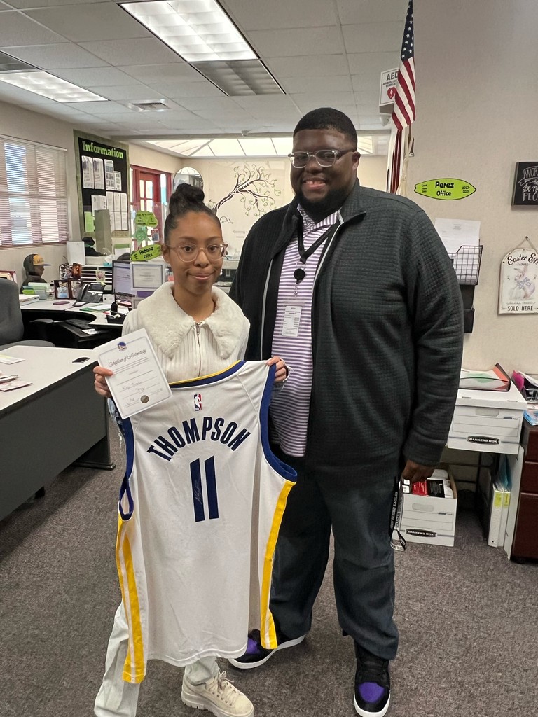 Director of School Nutrition, John McTear, presenting Kaylee Kendall with a autographed Klay Thompson jersey for winning the National School Breakfast Week Raffle Giveaway.