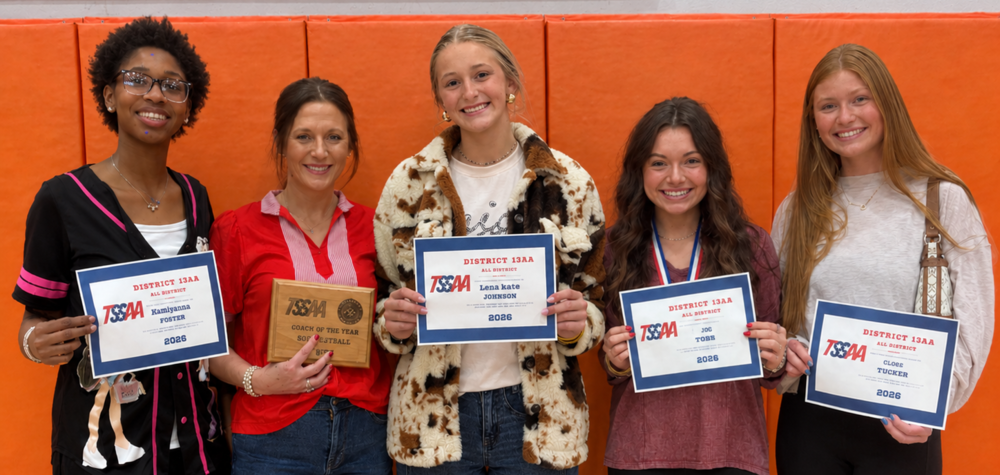 Four OCCHS volleyball players and their coach smile while holding certificates and a plaque.