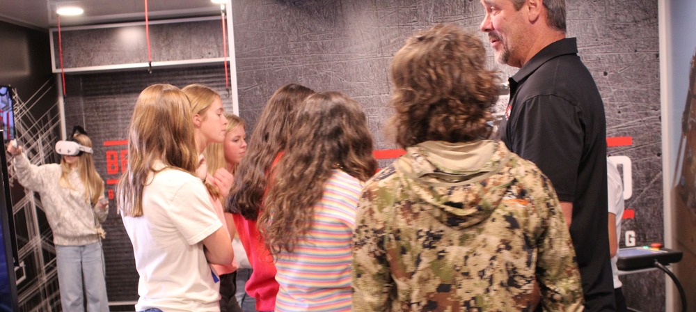 A group of OCCHS students listen as instructors explain about the Robotic Arm on the Be Pro, Be Proud truck.