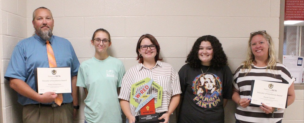 A group of students and teachers from SFHS smile while holding trophy and certificates.