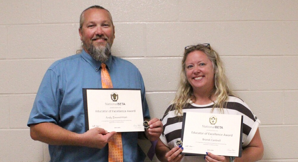Two teachers from SFHS smile while holding certificates.