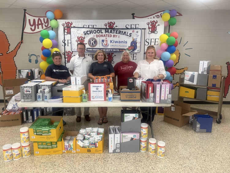 Group of Kiwanis Club members and school supplies