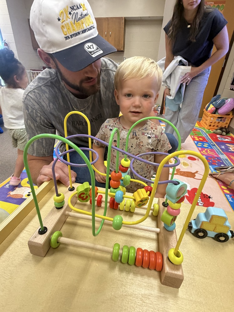 A father and young son playing with a toy